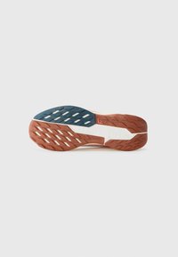 Sål i tre farver: marineblå, orange og hvid. Har dybe riller og en tekstureret gummioverflade for et godt greb. Distinkt lagdesign.