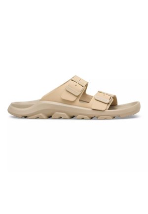 Sandalo beige a due cinturini con fibbie regolabili e suola spessa e texturizzata, progettato per comfort e presa all'aperto.