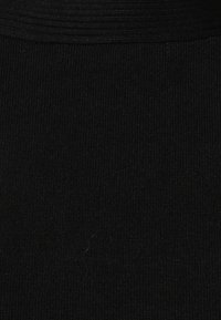 Czarna żebrowana tkanina o teksturowej powierzchni. Górna część zawiera szereg poziomych linii dla dodatkowego szczegółu.