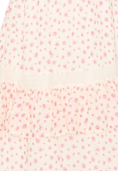 Witte stof met klein roze rozenpatroon en kantafwerking, met gelaagde ruches.