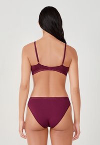 Soutien-gorge et bikini mauve avec bretelles réglables. Tissu en coton doux, design sans coutures et détails de couture subtils sur les bords.