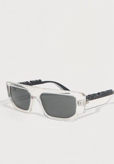 Διάφανα ορθογώνια γυαλιά ηλίου με σκούρους φακούς και μαύρο λογότυπο Dolce & Gabbana ανάγλυφο στις διάφανες βέργες.