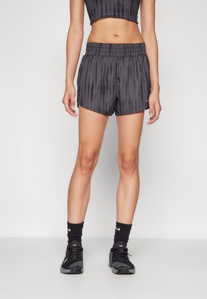 Schwarze Sportshorts mit einem dezenten vertikalen Streifenmuster, elastischem Bund und lockerer Passform, kombiniert mit schwarzen Turnschuhen und Socken.