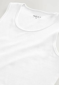 White tank top made of cotton, featuring a round neck and wide armholes. Brand label “NEXT” visible on the inside. Smooth texture.