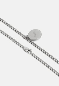 Silver chain necklace with an oval pendant featuring the engraved brand name. The chain links are interlocked and polished for a smooth finish.