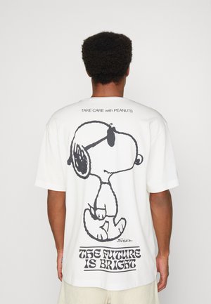 Weißes Baumwoll-T-Shirt mit einem großen schwarzen Grafik von Snoopy auf der Rückseite, mit dem Text "DIE ZUKUNFT IST HELL" darunter. Kurze Ärmel.