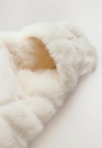 Weiches weißes Kunstfellprodukt mit flauschiger Textur und abgerundeten Kanten, einer glatten Innenseite und sichtbaren Nähten.