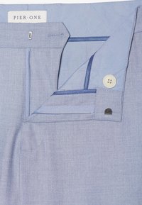 Helle blaue Hose mit Knopfverschluss, kontrastierender Innenverarbeitung und einer glatten Stofftextur mit einem dezenten Muster. PIER ONE Etikett sichtbar.