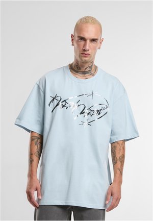 T-shirt oversize blu chiaro in cotone con un design grafico lucido nero e argento con stelle. Collo rotondo e maniche corte.