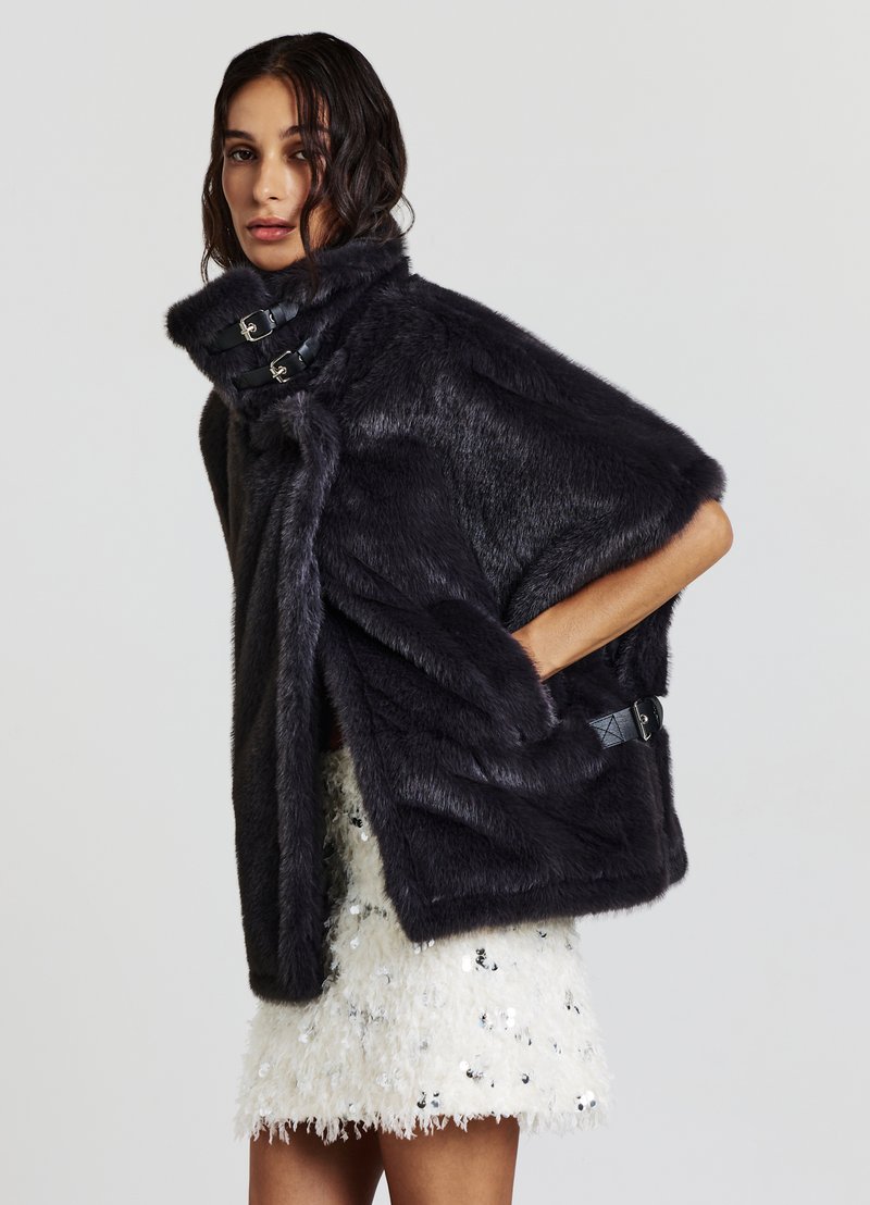 Cape en fausse fourrure gris foncé avec un col haut, arborant deux accents de boucle noirs. Texture lisse avec des manches larges et un design ouvert à l'avant.