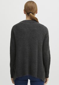Mörkgrå stickad tröja med en lös design, ribbad nederkant och sidoknappar, i ett strukturerat tyg och en något förlängd bakdel.