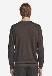 Schokoladenbrauner Pullover mit langen Ärmeln und rundem Ausschnitt. Weiche Textur, gerippte Bündchen und Saum. Klassische Passform mit glattem Finish.