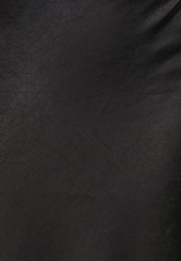 Musta kangas, jossa on sileä, matta tekstuuri ja hieno kiilto. Pintaa leimaa tasaisuus, ja siinä on vain vähän ryppyjä tai kuvioita.