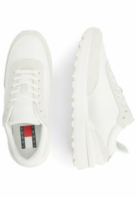 Sneaker bianche in rete e suede, con suola testurizzata, chiusura con lacci e etichetta logo con accenti rossi e blu sulla soletta.