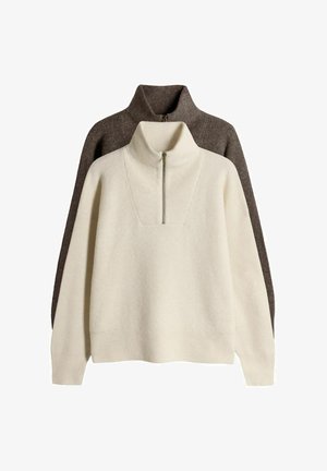 Zwei Kragensweatshirts übereinander gestapelt; eines in Creme mit strukturierter Rippung und einem Reißverschlusskragen, und eines in Dunkelbraun mit glatter Oberfläche.