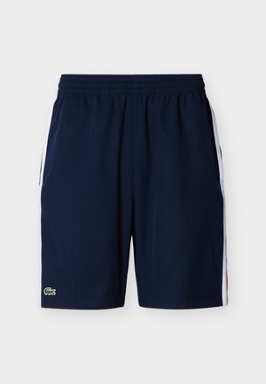 Marineblaue Sportshorts mit elastischem Bund und weißen Seitenstreifen, mit einem kleinen grünen Krokodil-Logo am linken Bein.