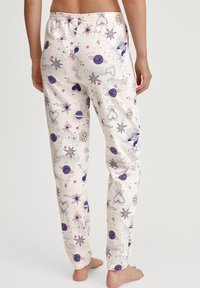 Crème kleurige pyjamabroek met een kleurrijke print van een ruimte-thema, met planeten, sterren en harten. Rekbare tailleband, zacht materiaal, smal ontwerp.
