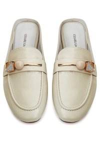 Beige Leder Slipper mit abgerundetem Zehenbereich, goldfarbenen Beschlägen und einem dekorativen Riemen mit einem Kunstperlen- und Strassbesatz.