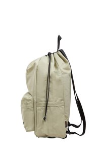 Sac à dos à cordon de serrage beige clair en tissu doux, avec un grand compartiment principal, une poche externe et des sangles réglables noires.