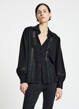 Schwarzes Hemd zum Knöpfen aus strukturiertem Stoff, mit Spitzenverzierungen entlang der Vorderseite und an den Ärmeln sowie Puffärmeln für mehr Volumen.