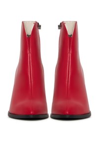 Paire de bottines en cuir rouge avec semelles noires, fermetures éclair latérales et dessus avant en forme de V, vues de dos.