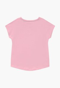 Růžové tričko s krátkým rukávem a kulatým výstřihem, vyrobené z jemné látky, s mírně zakulaceným lemem a bez viditelného vzoru či dekorací.