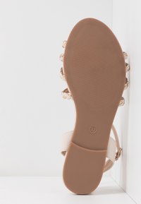Beige sandaalit, joissa on avoin varvas ja punottu yksityiskohta. Kestävä pohja, tasainen kanta. Koko 37 merkitty pohjaan.