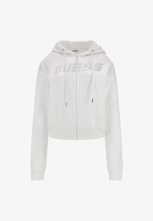 Haut à capuche court blanc en tissu doux, avec une fermeture éclair à l'avant, un cordon de serrage sur la capuche et un logo en strass "GUESS" sur la poitrine.