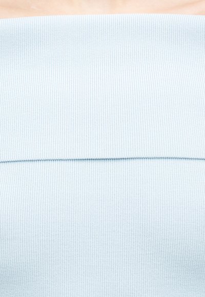 Κοντινό πλάνο διπλωμένου ριμπ πλεκτού υφάσματος ανοιχτού γαλάζιου χρώματος με ορατές οριζόντιες και κάθετες υφασματικές γραμμές.