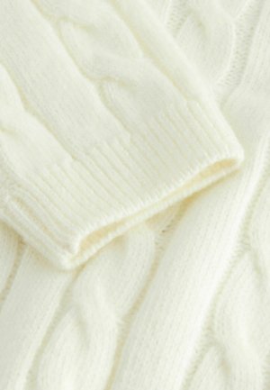 Sweter w warkocze w kolorze ecru, z prążkowanym dekoltem i mankietami. Miękka tekstura, klasyczny krój i szczegółowy wzór dzianiny.