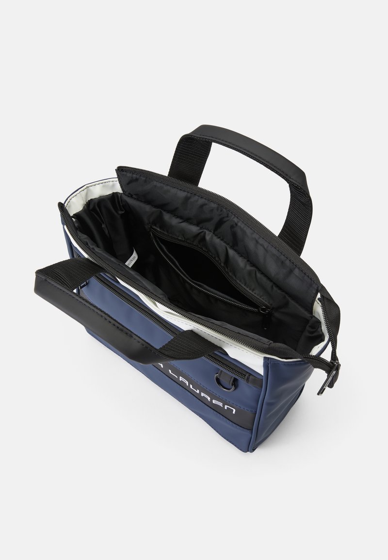 Bolsa aislante azul marino con ribetes negros, cierre de cremallera, asas dobles y múltiples bolsillos interiores para almacenamiento. Material duradero con textura suave.