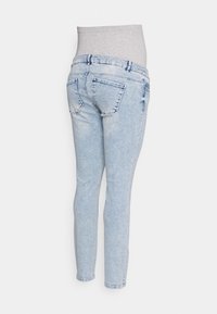 Jeans skinny azuis claros com uma cintura alta cinza elástica; apresenta bolsos traseiros e uma textura desbotada.