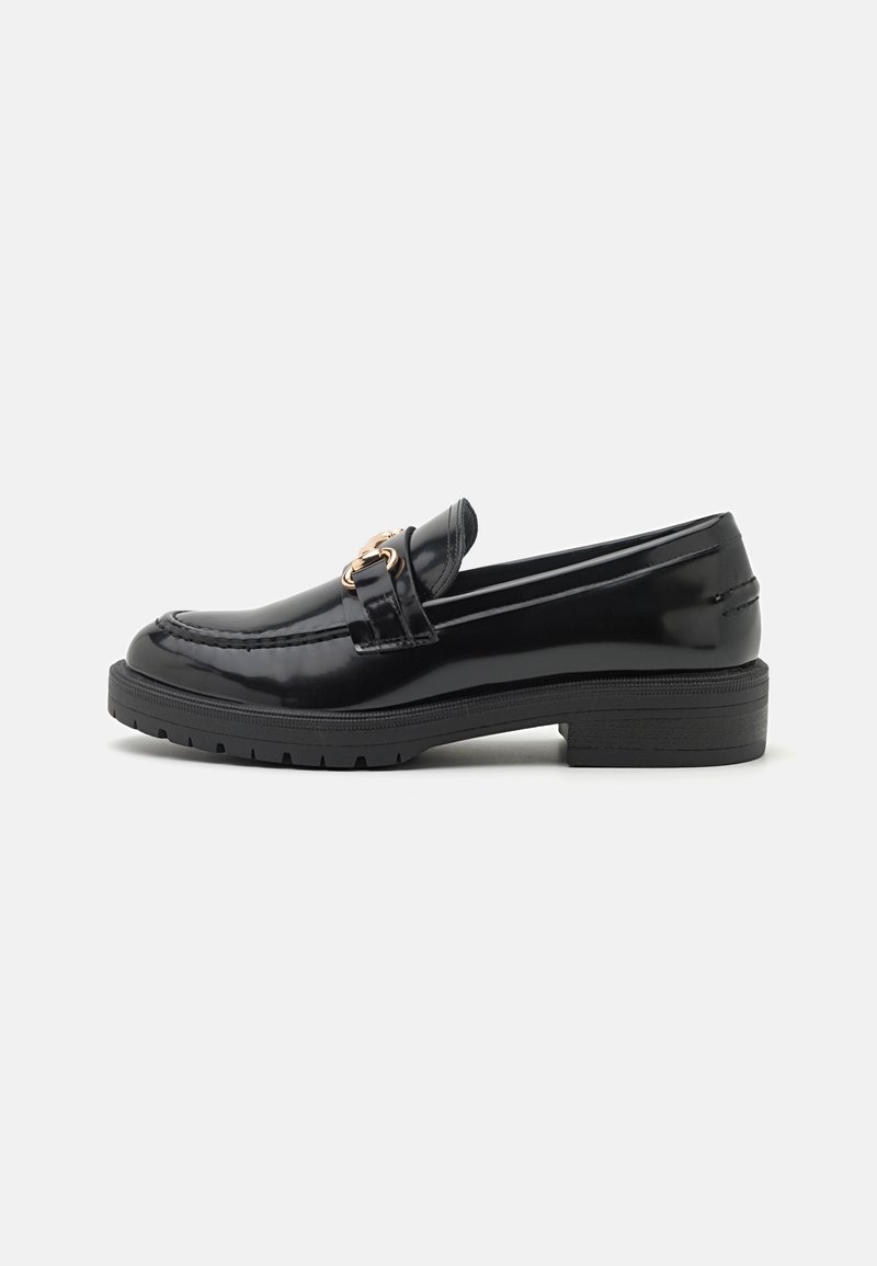 Mocassin en cuir noir brillant avec petit talon et boucle décorative en métal doré sur le côté, présenté de profil sur fond blanc.