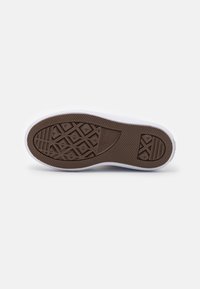Brown rubber shoe sole with diamond pattern and white edging. Features textured grip sections and logo imprint. Clean design, minimal detailing.