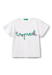 Camiseta de algodón blanca con mangas cortas acampanadas, que presenta un colorido diseño de texto "tropical" en verde y rosa. Cuello redondo, ajuste casual.