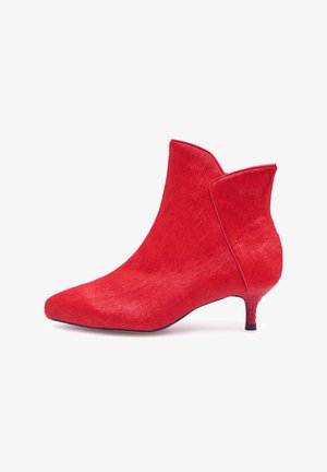 Stivaletto rosso alla caviglia con punta appuntita e tacco basso a gattino. Realizzato in materiale liscio e strutturato con un design angolare sul polsino.