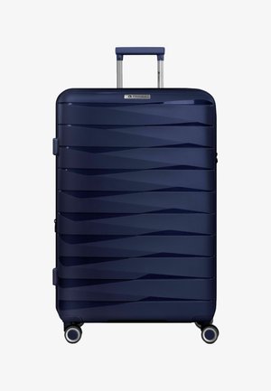Grote donkerblauwe harde koffer met horizontale ribbels, uittrekbare handgreep en vier zwenkwieltjes op een witte achtergrond.