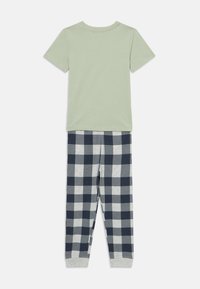 Groene korte mouwen shirt gecombineerd met grijze en marineblauwe geruite pyjamabroek. Katoenen materiaal, met een elastische tailleband en manchetten.
