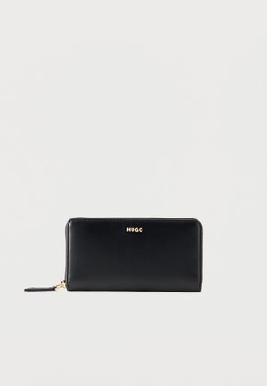 Black leather zip-around wallet with gold "HUGO" logo and gold zipper pull tab on a light background.