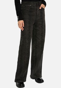 Jeans larges noirs avec une texture subtile imprimée serpent, fabriqués en denim à la finition lisse. Dotés d'un style classique à cinq poches et de passants de ceinture.