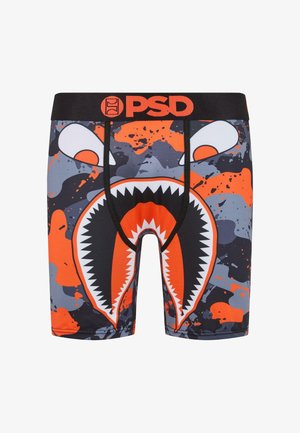 Boxer-briefs noirs présentant un graphique audacieux d'une bouche ouverte avec des dents acérées, accentuée par des motifs de éclaboussures orange et gris et une ceinture de marque.