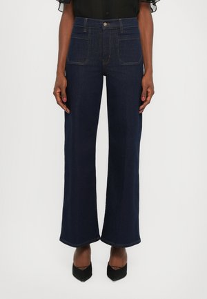 Dark blue wide-leg jeans with a high waist, five pockets, and contrasting stitching details. Fabric has a smooth, sturdy texture.