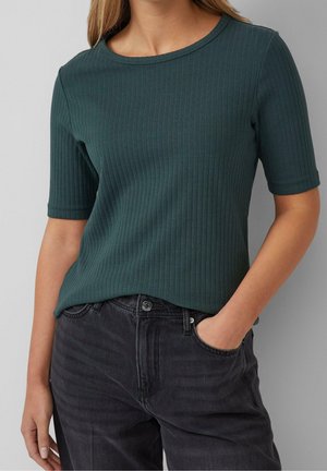 Prążkowany, ciemnozielony t-shirt z okrągłym dekoltem i krótkimi rękawami, zestawiony z czarnymi jeansami. Tkanina wydaje się miękka i fakturowana.