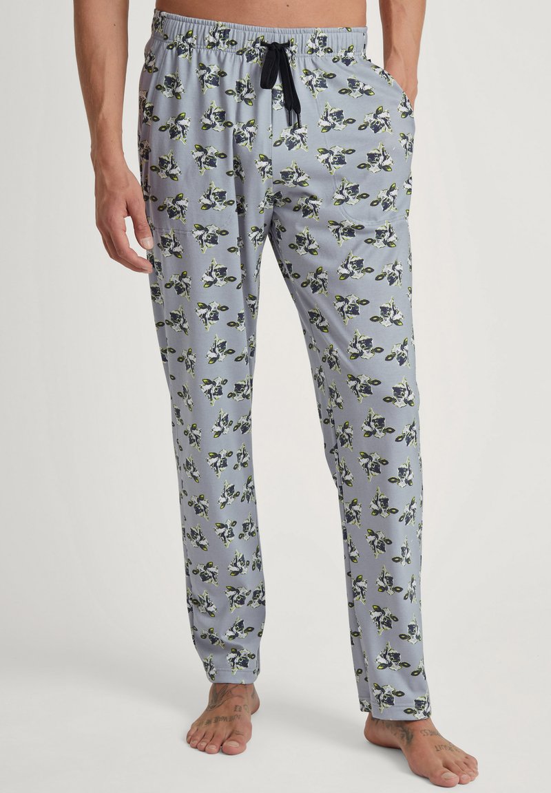 Lichtblauwe pyjamabroek met een bloemenpatroon met groene en zwarte accenten, een elastische tailleband met trekkoord en zijzakken.