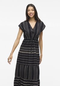 Abito maxi blu navy con motivi beige, caratterizzato da un collo a V, maniche corte e una vita con cordoncino. Gonna svasata con design a strati.