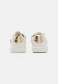 Witte sneakers met een gladde leren afwerking, voorzien van metallic gouden accenten op de hiel en een gestructureerde witte zool.