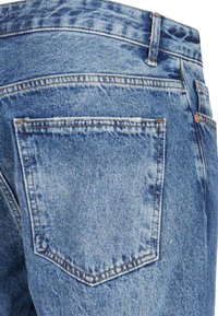 Lysblå denimjeans med en falmet tekstur, der har en baglomme og synlige sømme langs sømmene.