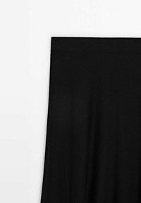 Panneau rectangulaire en tissu noir avec une texture minimale sur fond blanc, montrant le coin supérieur gauche et le bord.