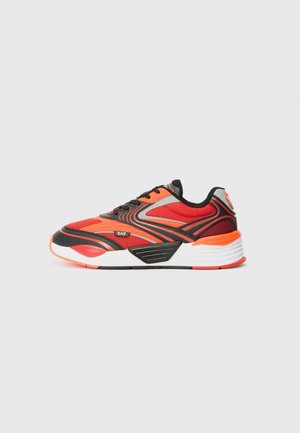 Baskets rouges et orange avec des accents noirs, semelle blanche et design à lacets, vues de côté sur un fond gris clair uni.