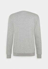Sudadera gris de manga larga con cuello redondo y puños acanelados. Confeccionada en una suave tela texturizada. Color sólido y simple, sin patrones ni acentos.